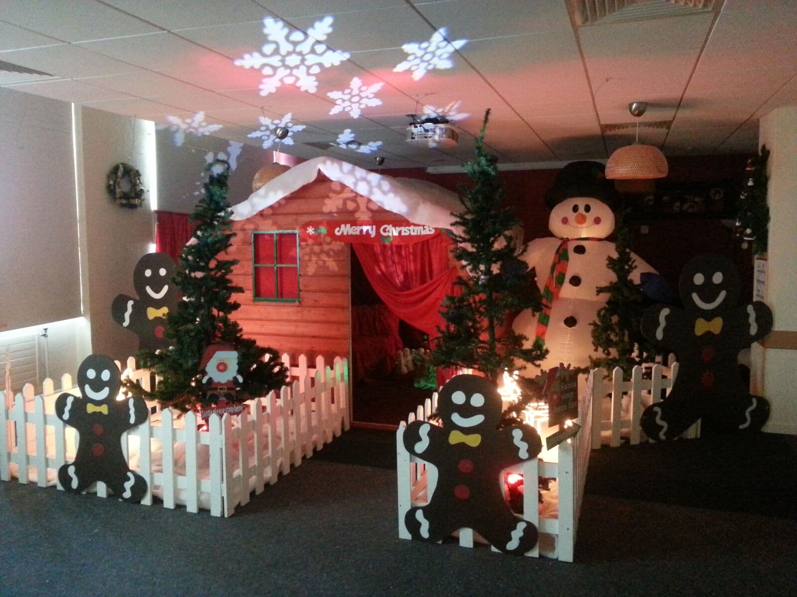 an office has been transformed into a magical winter wonderland with a Santa's grotto, inflatable snowman, and other Christmas decorations for a Kid's Christmas party in Dublin