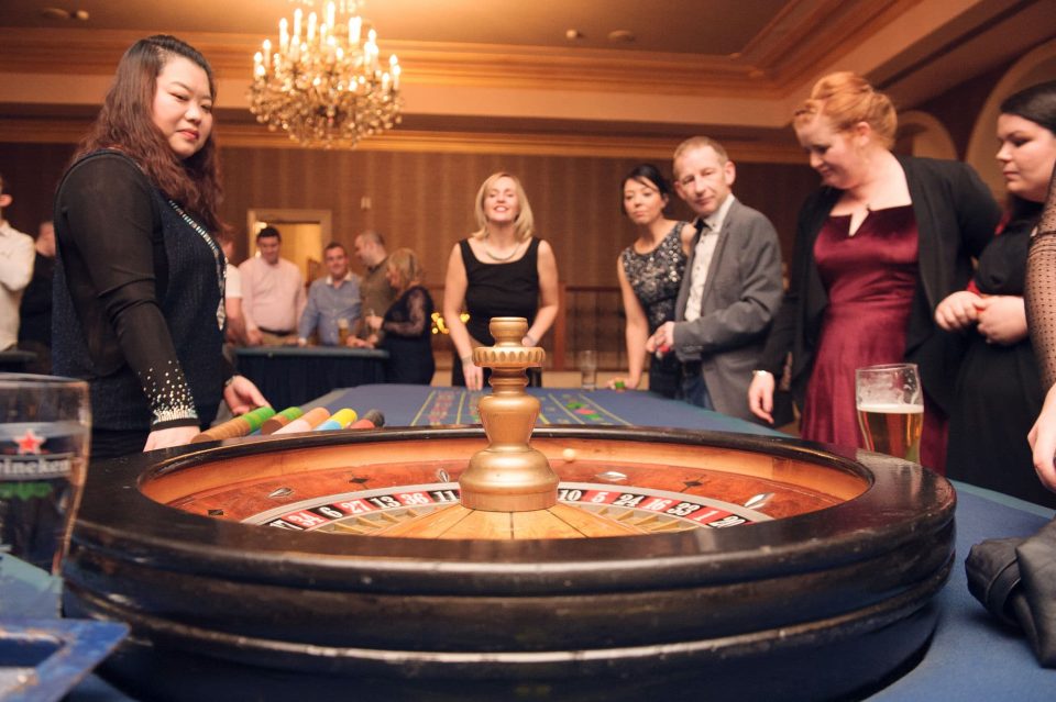 Theme Parties That Transform Corporate Events 2 a group of employees are enjoying the roulette table at a Vegas night themed corporate event in Dublin