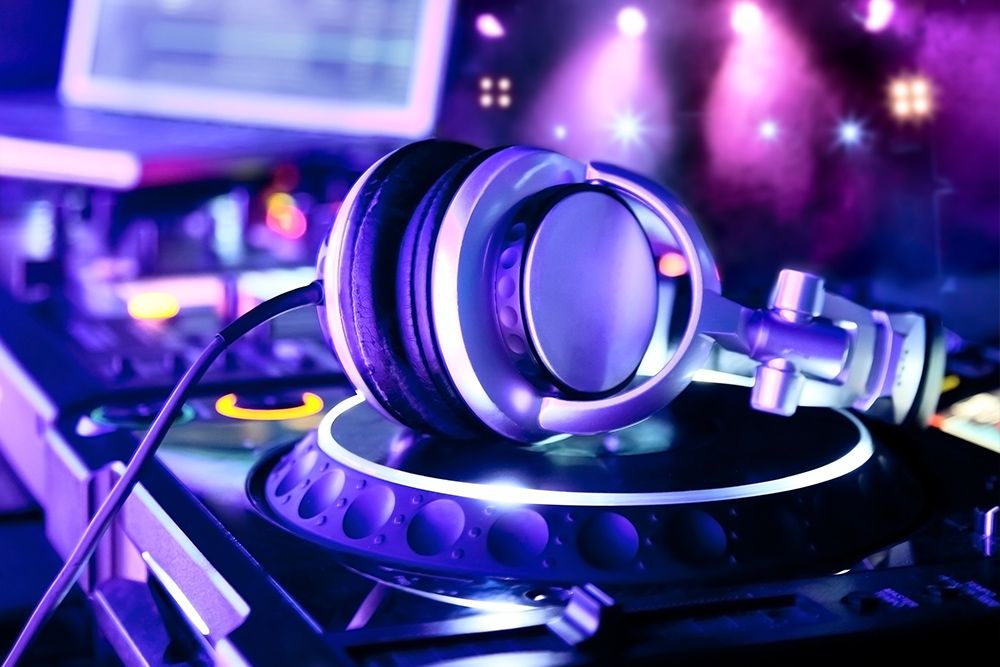 DJ headphones resting on turntables on stage at an indoor event
