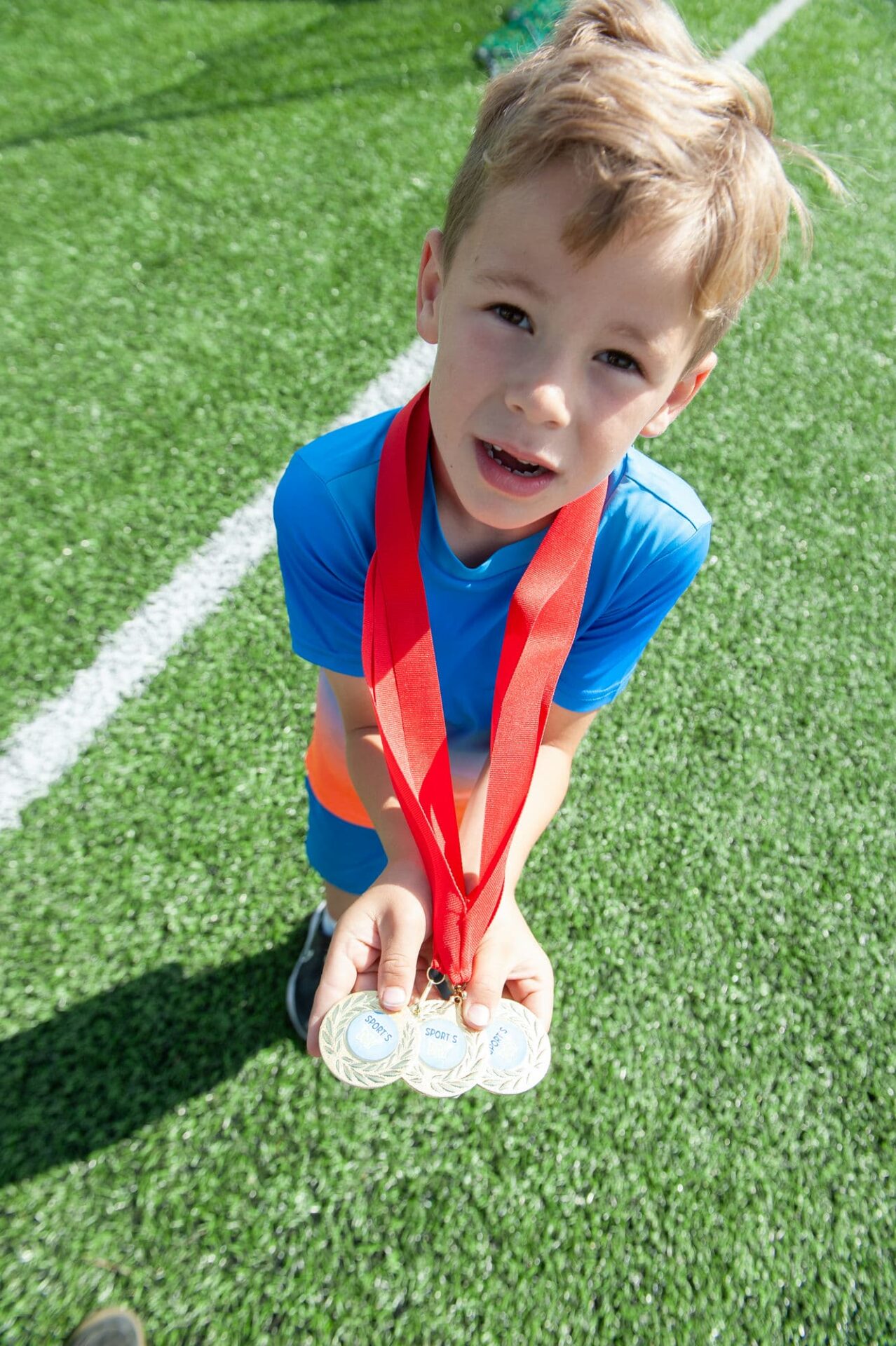 A young boy shows his medals that he won for taking part in sports games at a family fun day summer party in Kilkenny