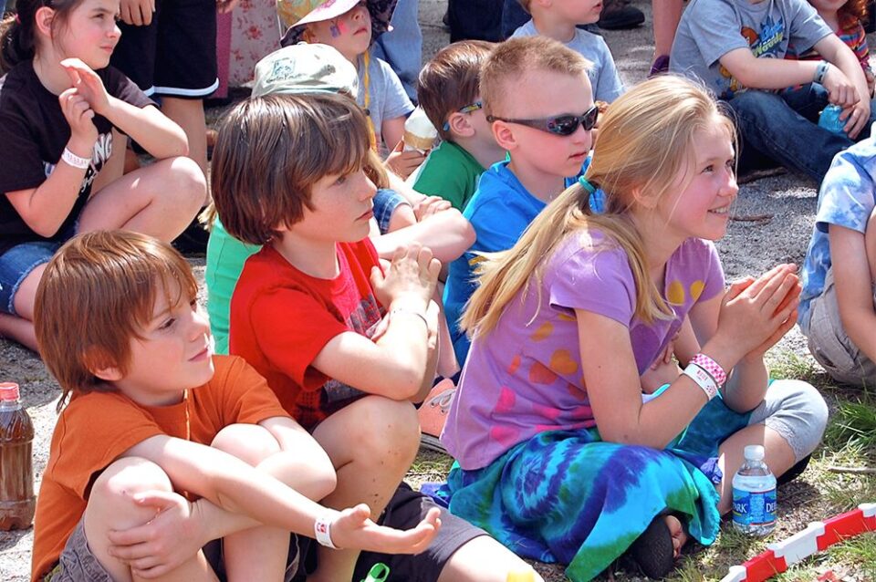 young families enjoy the entertainment at an outdoor summer event