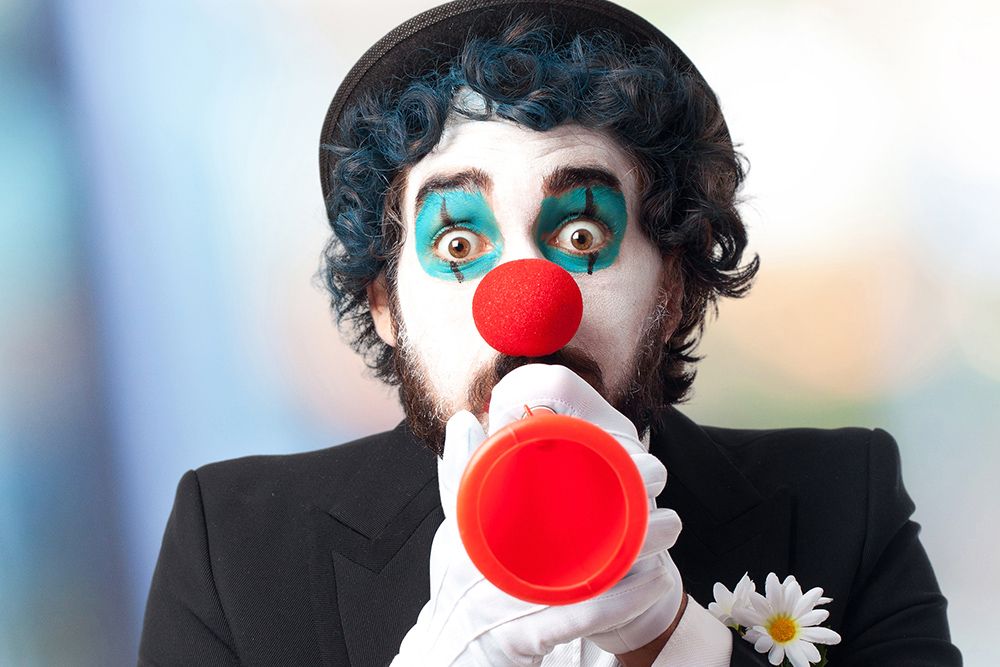 clown with red nose and white face at a kids event