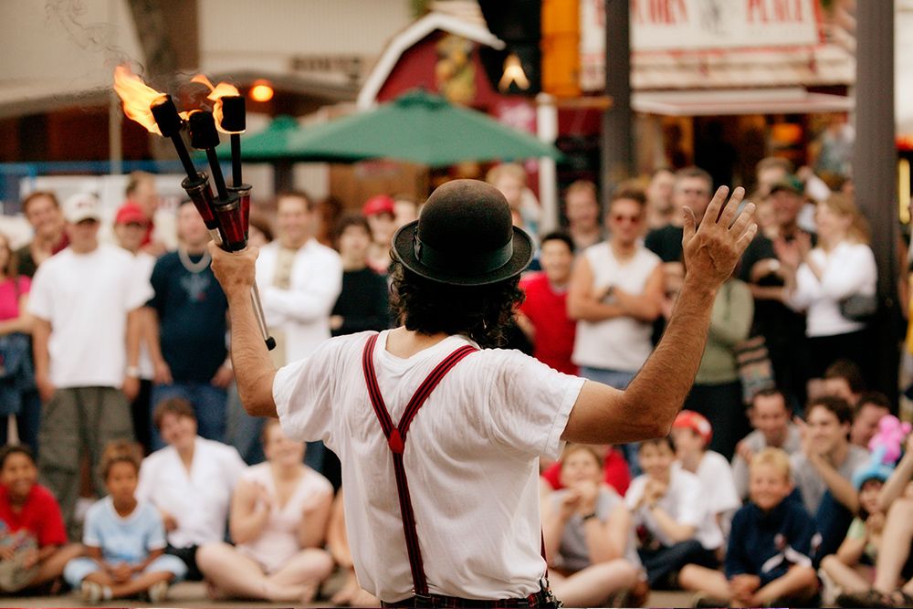 A street performer dazzling a happy crowd of kids at an indoor family event