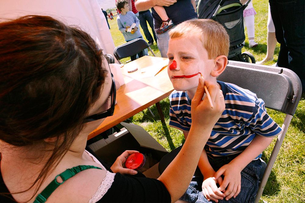 photo of a young boy getting his face painted at a summer kids party