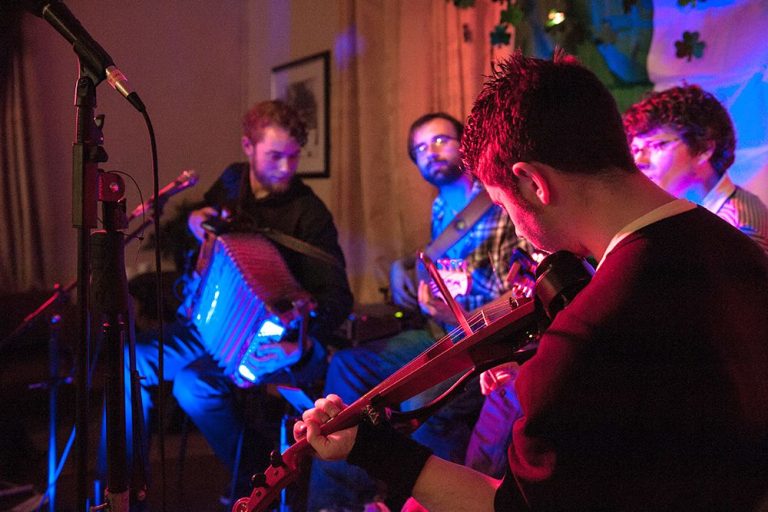 photo of traditional irish musicians playing on stage at an indoor event