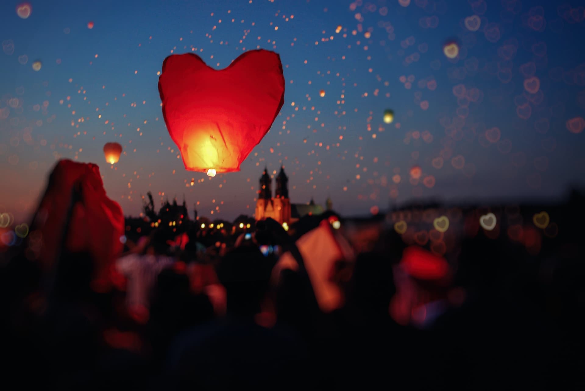 paper lanterns floating up into the sky at an outdoor event